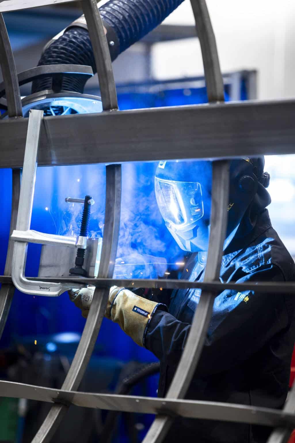 Operatör som svetsar rostfria komponenter i industriell produktion hos IS Plåt