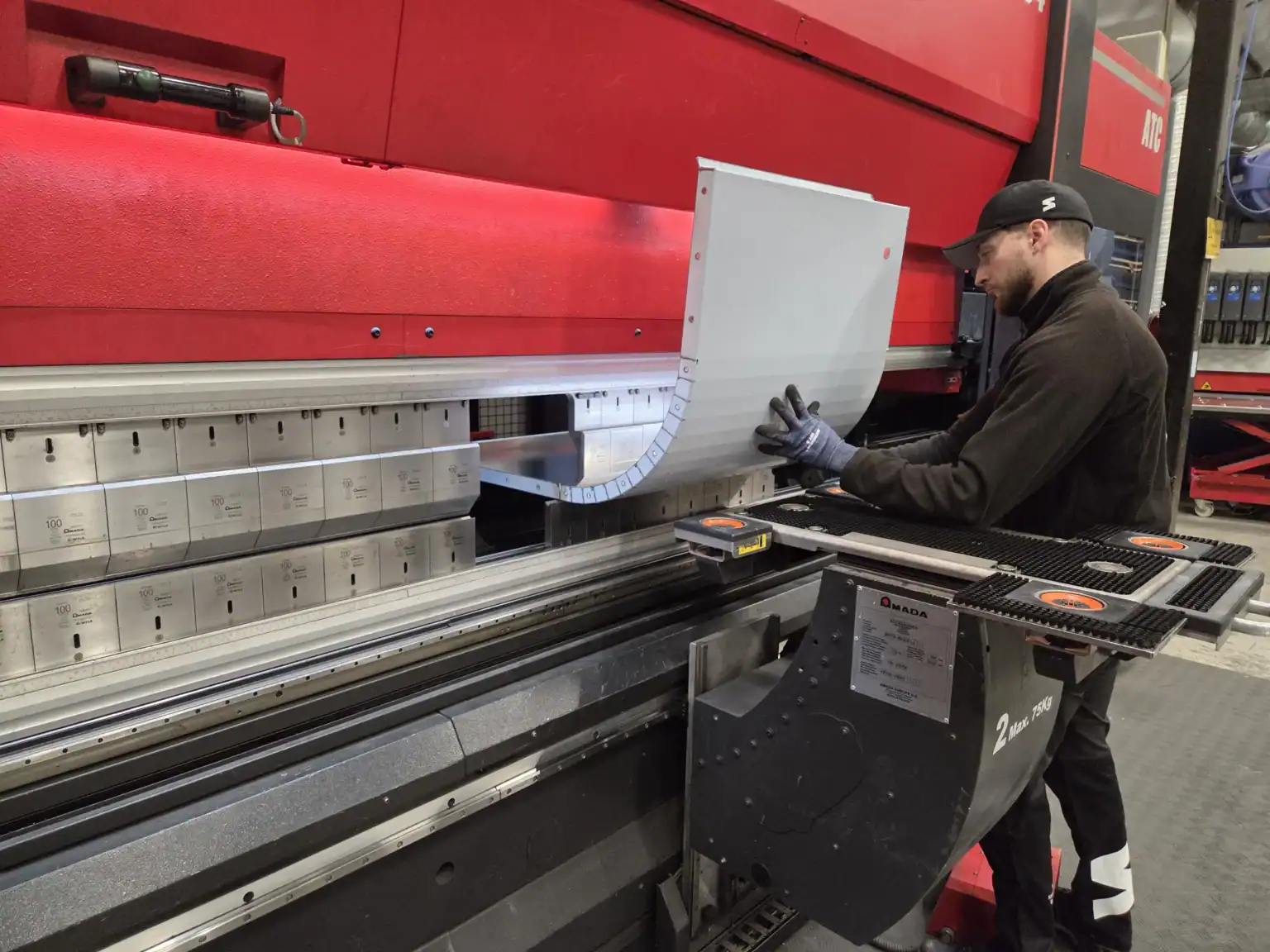 Operatör som bockar plåt i industrimaskin där materialets egenskaper påverkar precision och resultat i produktionen